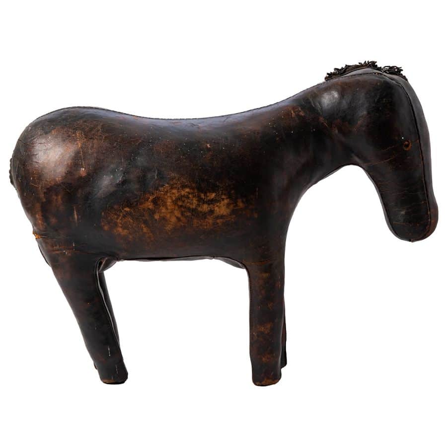 Close-up of antique leather horse footstool, showcasing aged patina and intricate details.