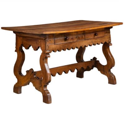 Antique chestnut desk with intricate carvings, two drawers, and original pulls.