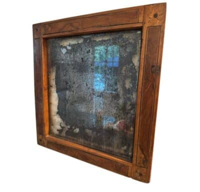 Antique English mirror in walnut, showcasing original faded mercury glass with intricate corner details.