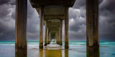 Striking perspective shot of Scripps Pier on acrylic, showcasing its iconic structure against a dramatic sky.
