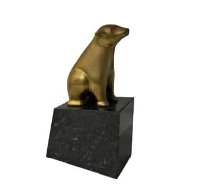 Gold bear statue on marble pedestal, vintage charm from 1960s.