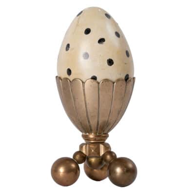 Close-up of heavy vintage stone decorative spotted ostrich egg in brass tripod ball stand.