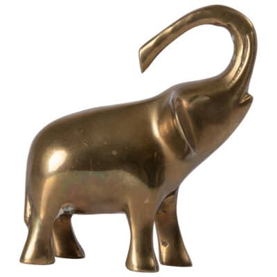 Close-up of vintage brass elephant sculpture with raised trunk, showcasing intricate details and mid-century modern design.