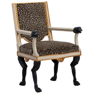 Armchair with leopard print upholstery and lion legs.