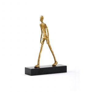 Gold walking man statue on a black pedestal