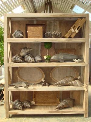 Extra large teak bookcase with various items on shelves, set against a backdrop of wooden planks and natural light.