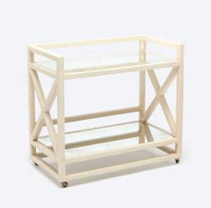 A wooden bar cart with a faux raffia finish and two antiqued mirror shelves, available in black or off-white.
