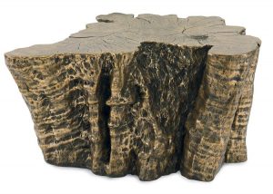 A large, rustic coffee table made of a cast stone stump with a bronze metal finish.
