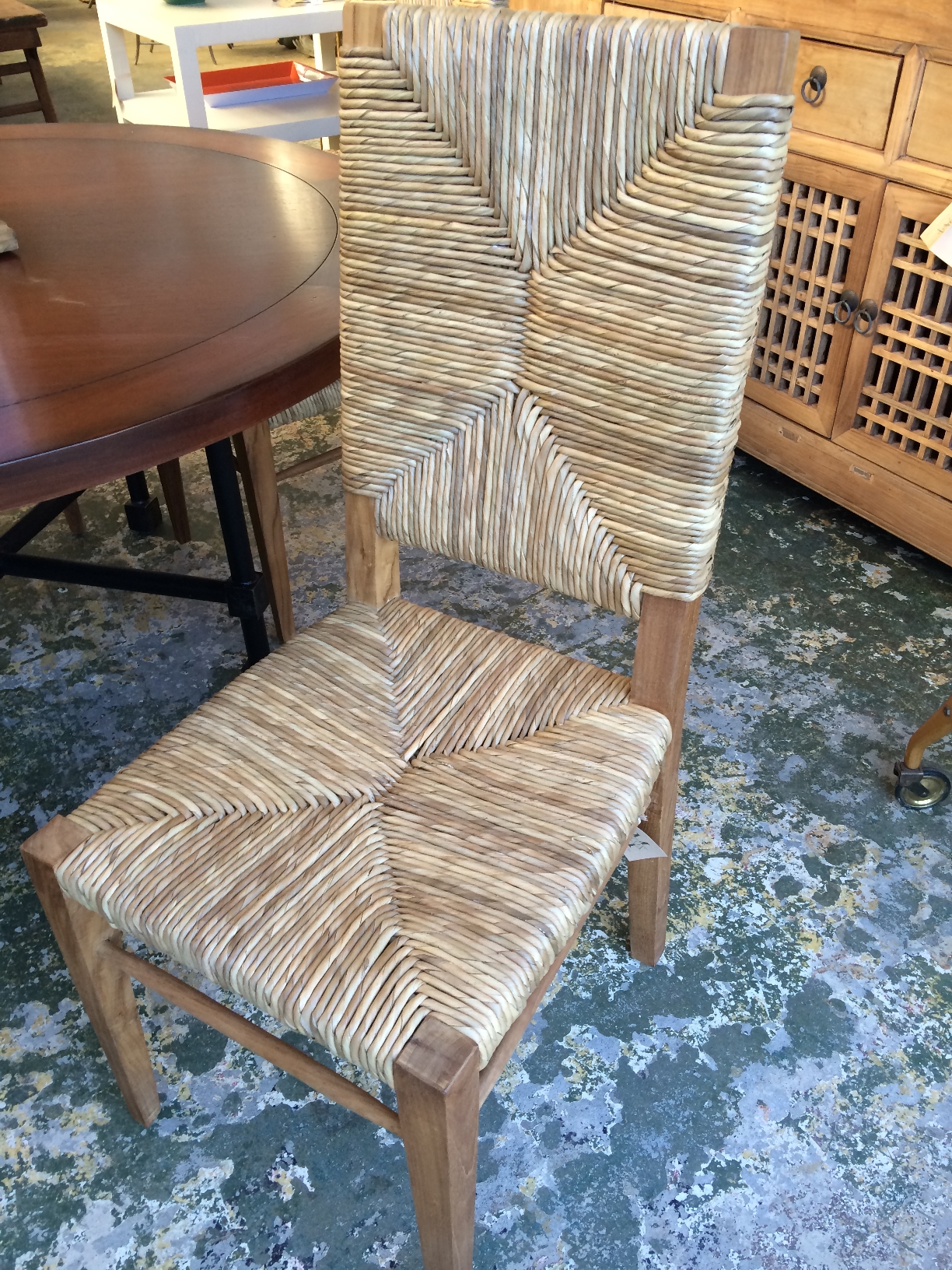 Large wooden dining chair with a woven seat and back, featuring a combination of teak and seagrass materials.