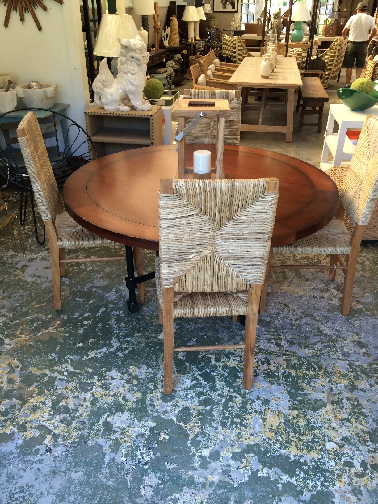 Large wooden dining chair with woven seat and back featuring a teak frame and seagrass upholstery set against a patterned wall in
