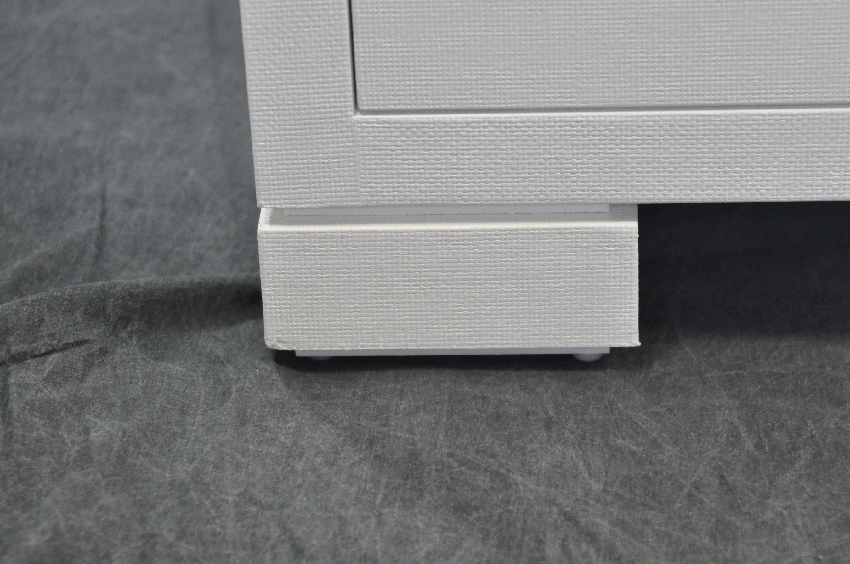 White six drawer dresser with black handles on a dark surface