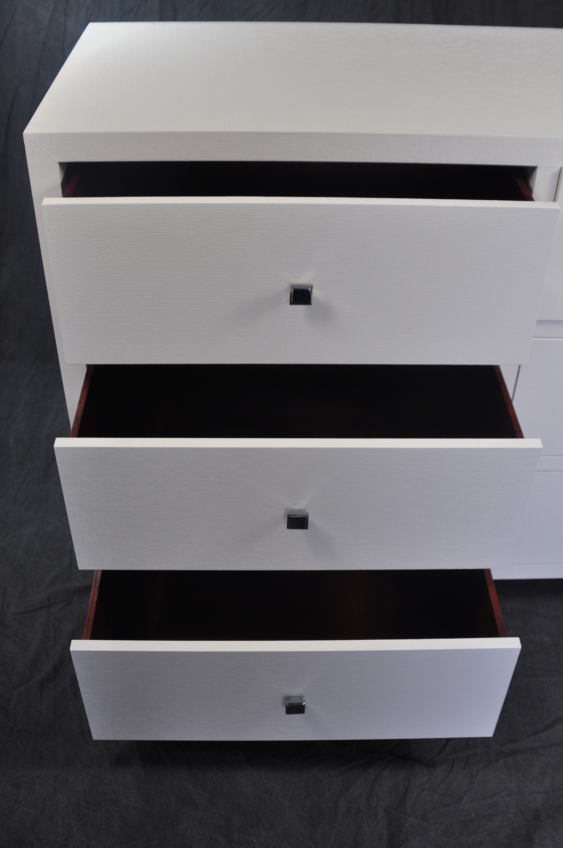 White six drawer dresser with red interior, set against a dark background.
