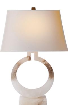 A tall table lamp with a large round base featuring an alabaster finish and a natural paper shade The lamp has a