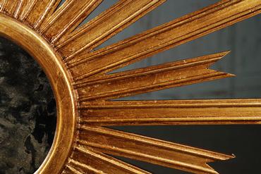 Gold starburst mirror with intricate hand carving details