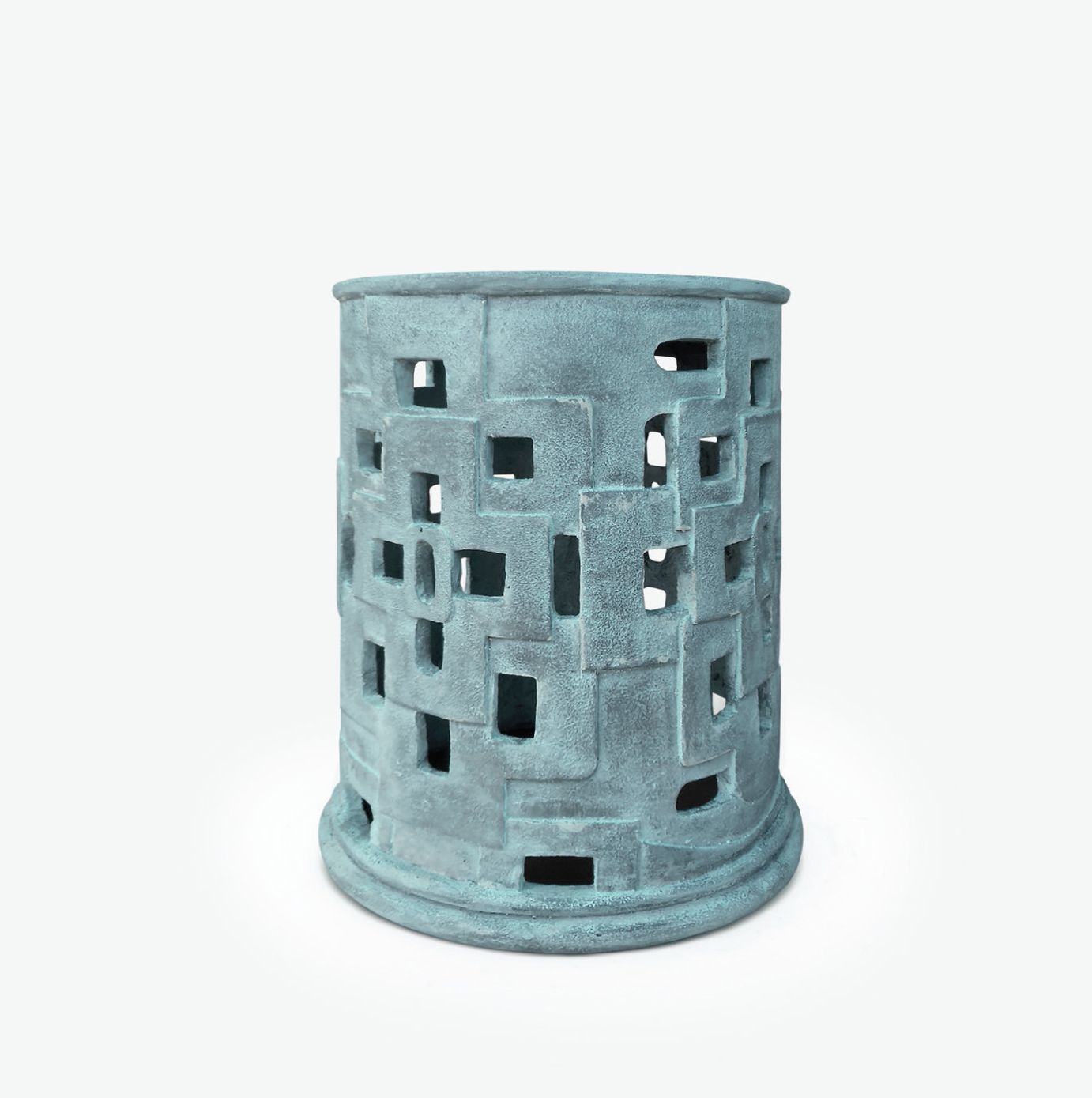 A handcrafted concrete stool with a geometric design featuring cutouts and variations in size between pieces available in light grey or verdigris