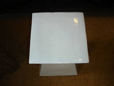 White abstract ceramic garden stool on display in a store.