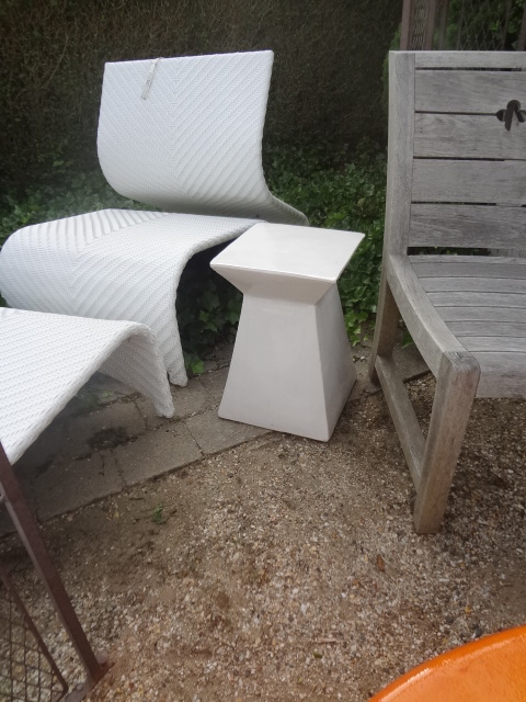 White abstract ceramic garden stool in outdoor setting